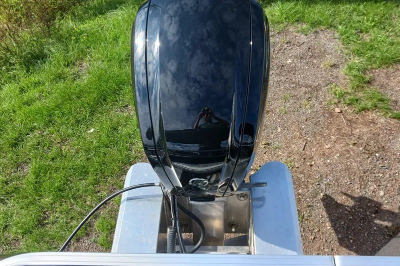 Slide: The Image of 2026 Sun Tracker Bass Buggy 18 DLX outboard motor on grassy terrain. - 13
