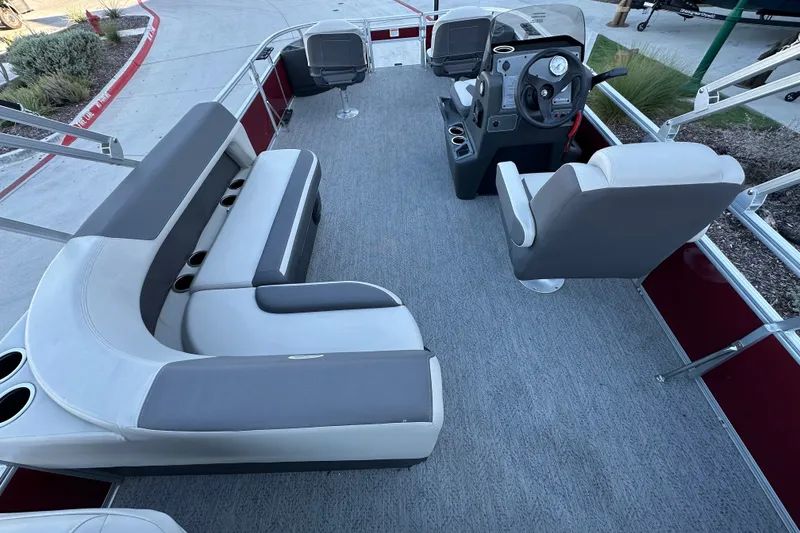 Slide: The Image of 2026 Sun Tracker Bass Buggy 18 DLX pontoon boat interior with seating and steering console. - 20