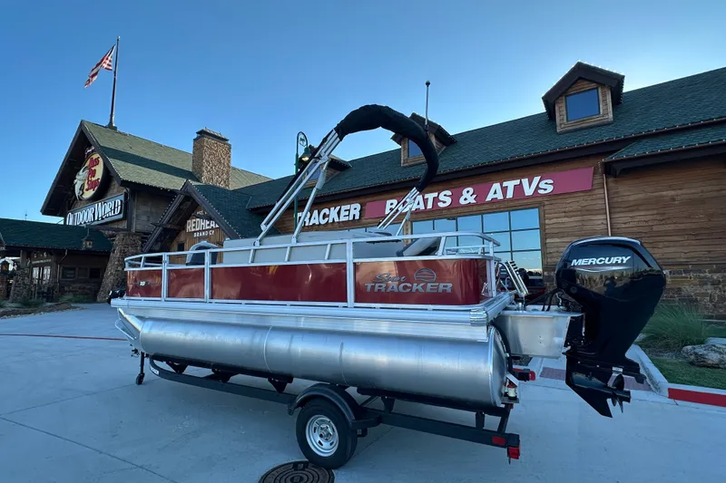 The Image of 2026 Sun Tracker Bass Buggy 18 DLX pontoon boat outside Bass Pro Shops. - 2
