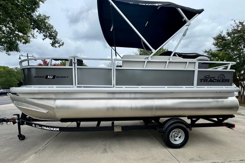 The Image of 2026 Sun Tracker Bass Buggy 18 DLX pontoon boat on trailer, parked outdoors. - 0