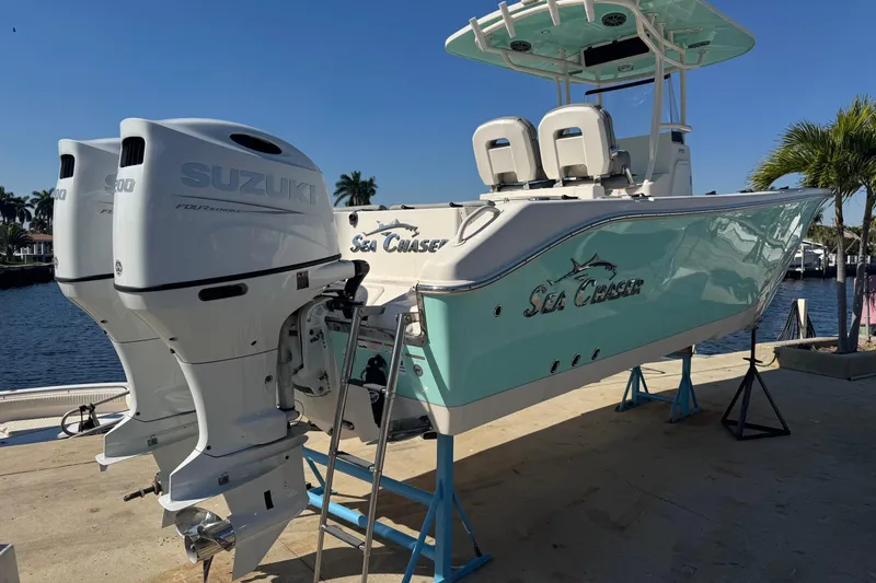 The Image of 2023 Sea Chaser 27 HFC CC boat with twin Suzuki engines docked by the water. - 0
