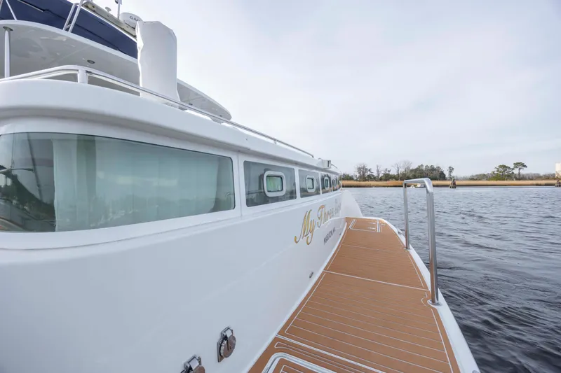 Slide: The Image of 2004 Lagoon 43 PC yacht on water, showcasing sleek design and spacious deck. - 17