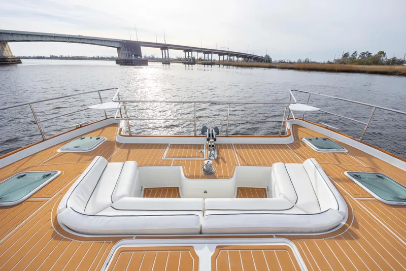 Slide: The Image of Luxurious 2004 Lagoon 43 PC yacht deck with white seating, overlooking serene waters and a bridge. - 22