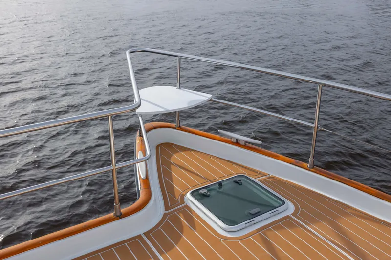 Slide: The Image of Bow of 2004 Lagoon 43 PC yacht with teak deck and railing on water. - 23