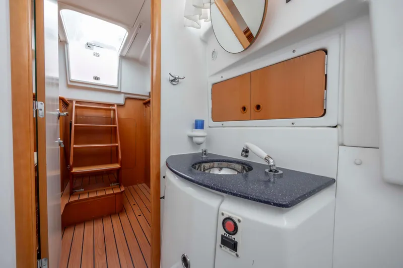 Slide: The Image of Lagoon 43 PC 2004 yacht interior with wooden stairs, sink, and storage cabinets. - 42