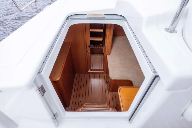 Slide: The Image of Interior view of 2004 Lagoon 43 PC yacht, showcasing wooden flooring and seating area. - 44