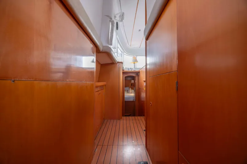 Slide: The Image of Interior hallway of 2004 Lagoon 43 PC yacht with wooden paneling and cozy cabin. - 46