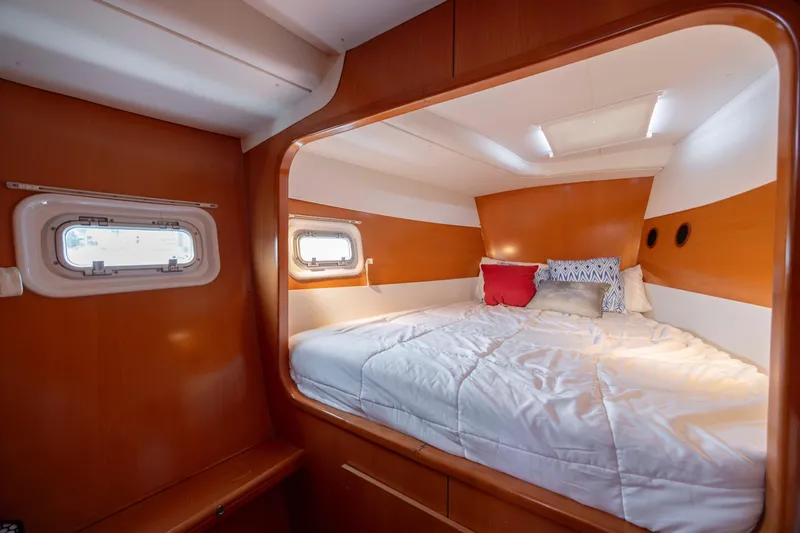Slide: The Image of Cozy cabin interior of 2004 Lagoon 43 PC yacht with comfortable bedding and porthole windows. - 47