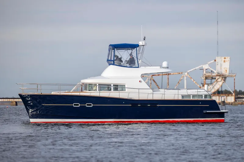 Slide: The Image of 2004 Lagoon 43 PC yacht on water, featuring sleek design and blue hull. - 5