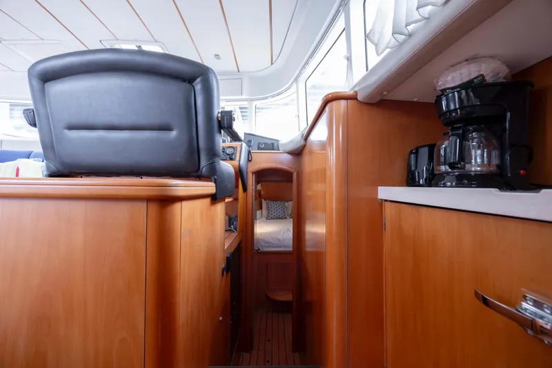 Slide: The Image of Interior of 2004 Lagoon 43 PC yacht with wooden cabinetry and coffee maker. - 53