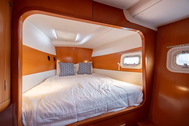 Slide: The Image of Luxurious cabin interior of 2004 Lagoon 43 PC yacht with cozy bedding and porthole windows. - 54