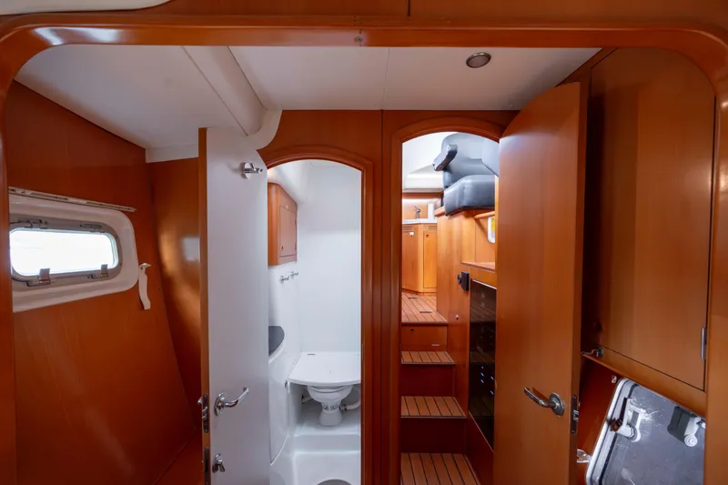 Slide: The Image of Interior of 2004 Lagoon 43 PC yacht with wooden cabinetry and compact bathroom. - 56