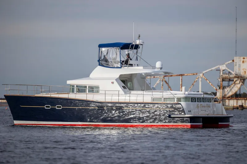 Slide: The Image of 2004 Lagoon 43 PC yacht on water, featuring sleek design and blue hull. - 6