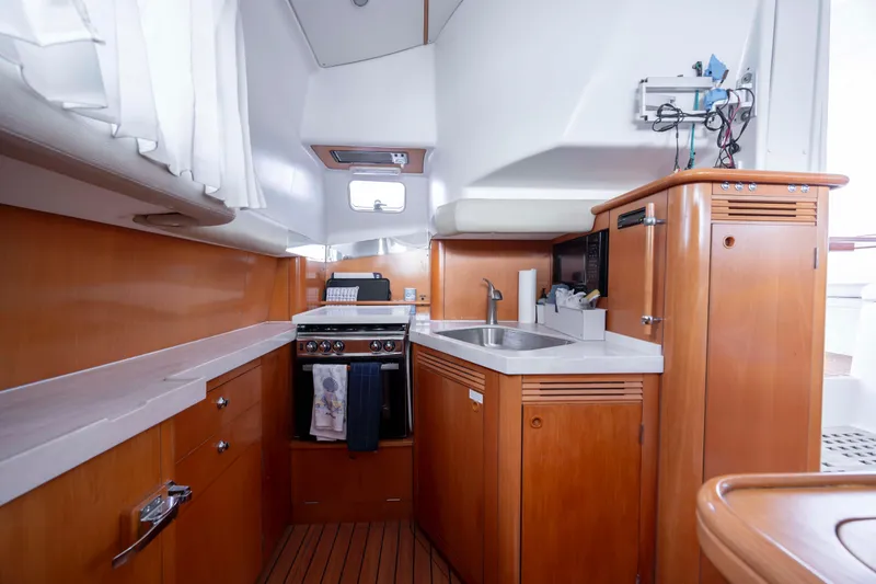Slide: The Image of Interior of 2004 Lagoon 43 PC yacht kitchen with wooden cabinetry and modern appliances. - 60