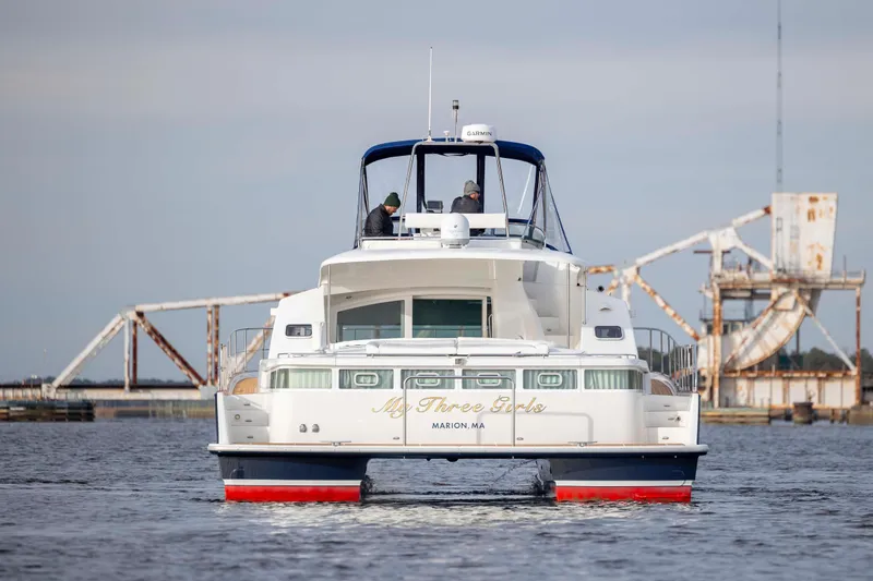 Slide: The Image of 2004 Lagoon 43 PC yacht cruising near a bridge, rear view. - 8