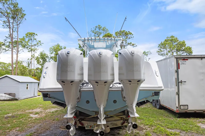 Slide: The Image of 2016 SeaHunter 41 Tournament boat with triple outboard engines, parked outdoors. - 10