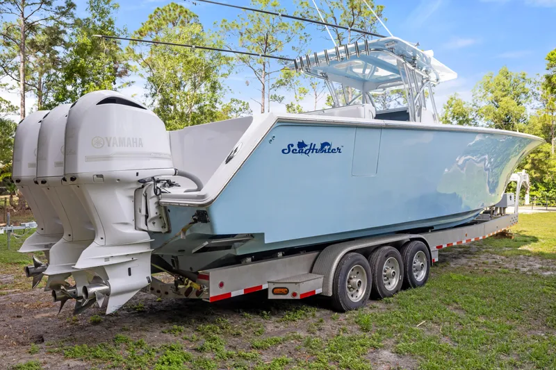 Slide: The Image of 2016 SeaHunter 41 Tournament boat on trailer with triple Yamaha engines, parked outdoors. - 11