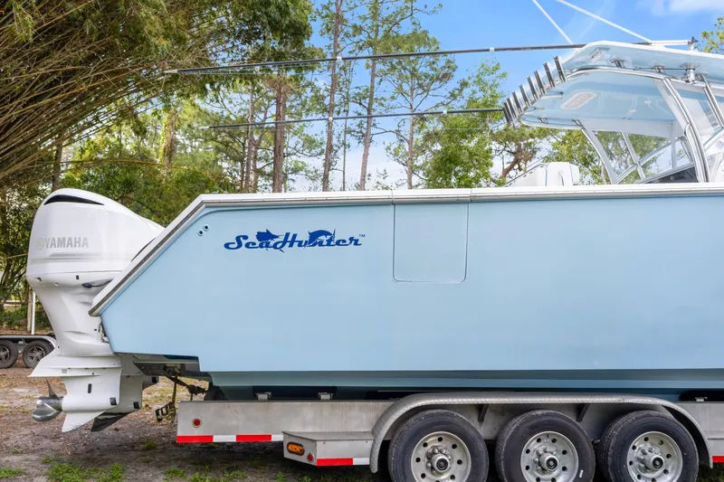 Slide: The Image of 2016 SeaHunter 41 Tournament boat on trailer with Yamaha engines, surrounded by trees. - 13