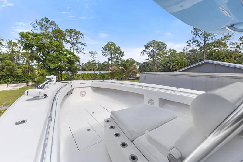 Slide: The Image of 2016 SeaHunter 41 Tournament boat deck with seating, surrounded by lush greenery and clear skies. - 26