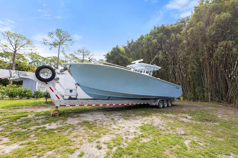 Slide: The Image of 2016 SeaHunter 41 Tournament boat on trailer, parked outdoors with trees in background. - 4