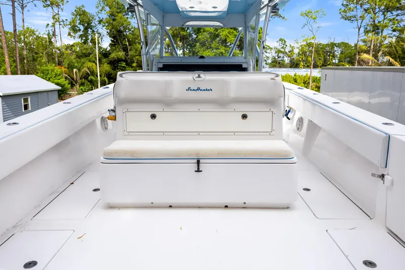 Slide: The Image of 2016 SeaHunter 41 Tournament boat interior with seating and storage, surrounded by lush greenery. - 42