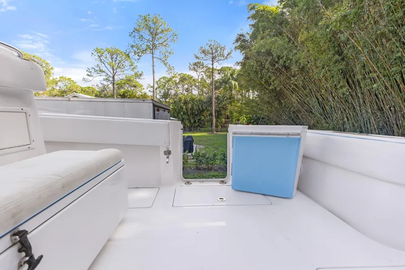 Slide: The Image of 2016 SeaHunter 41 Tournament boat interior with seating and cooler, surrounded by lush greenery. - 54