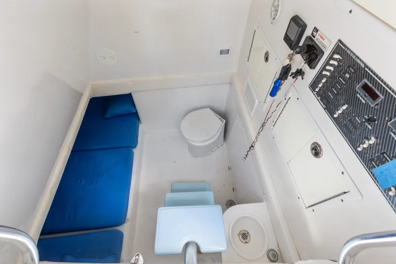 Slide: The Image of 2016 SeaHunter 41 Tournament cabin interior with blue cushions and control panel. - 56