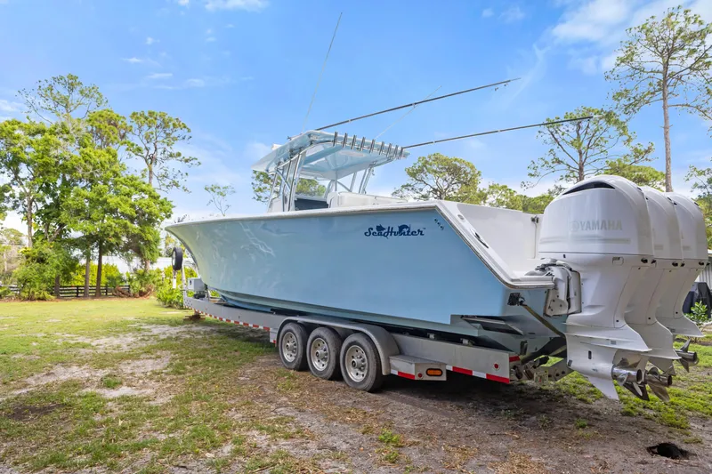 Slide: The Image of 2016 SeaHunter 41 Tournament boat on trailer, featuring triple Yamaha engines, parked outdoors. - 6