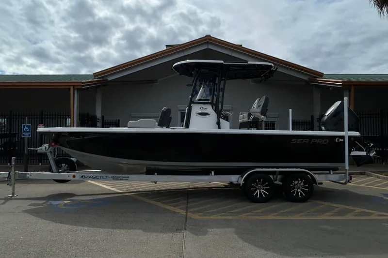 The Image of 2026 Sea Pro 250 Bay boat on trailer, parked outside a building. - 0