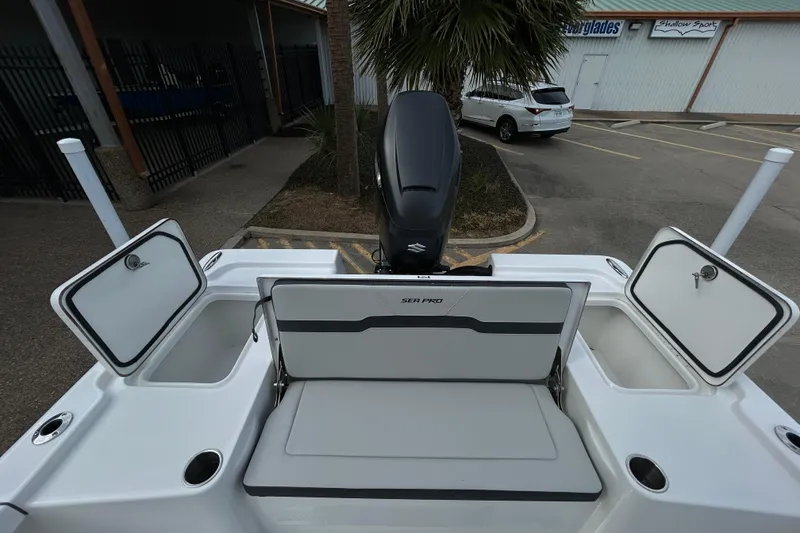 Slide: The Image of 2026 Sea Pro 250 Bay boat with open storage compartments and outboard motor. - 10