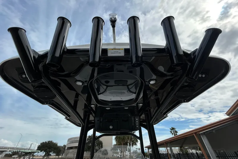 Slide: The Image of 2026 Sea Pro 250 Bay boat with rod holders, viewed from below against a cloudy sky. - 14