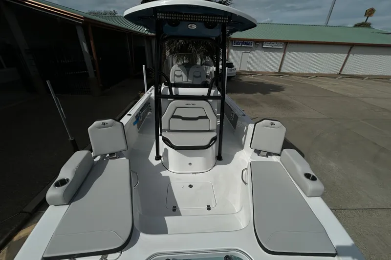 Slide: The Image of 2026 Sea Pro 250 Bay boat interior with seating and console, parked outdoors. - 22