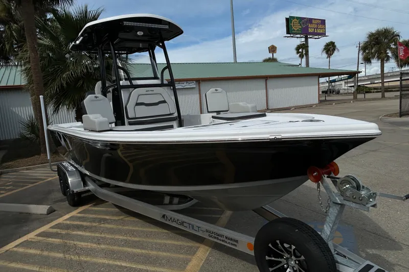 Slide: The Image of 2026 Sea Pro 250 Bay boat on trailer, parked outdoors near palm trees. - 5