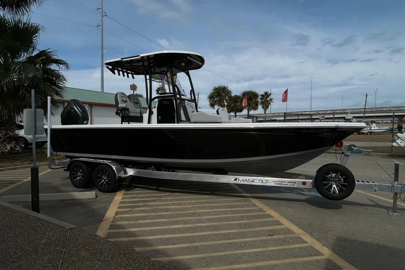 Slide: The Image of 2026 Sea Pro 250 Bay boat on trailer, parked outdoors, under a cloudy sky. - 6