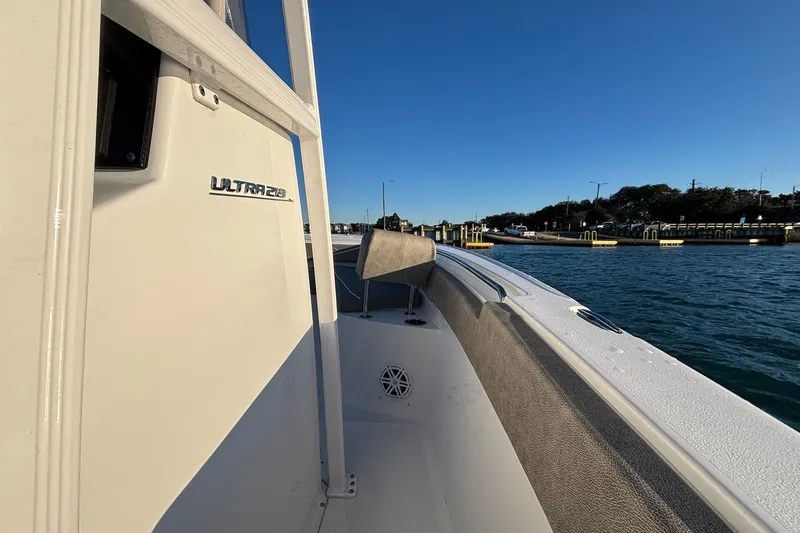 Slide: The Image of 2026 Sea Hunt Ultra 219 boat docked, showcasing sleek design and spacious deck. - 8
