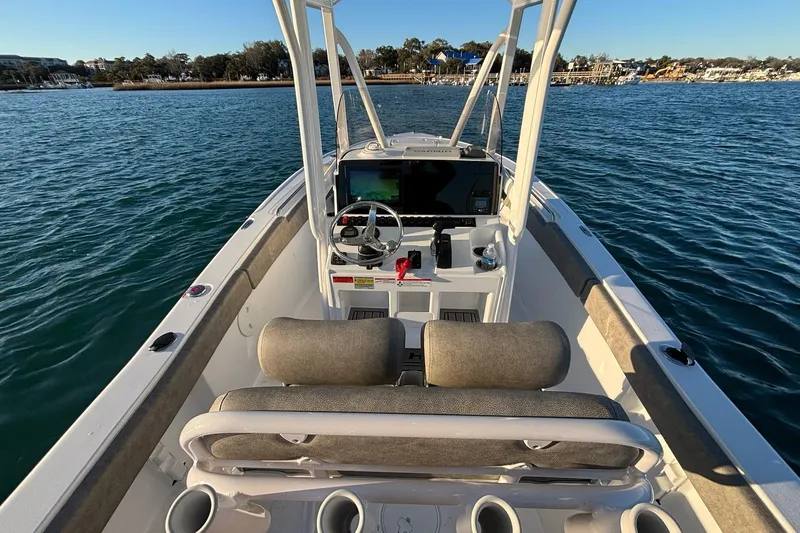 Slide: The Image of 2026 Sea Hunt Ultra 219 boat interior with steering console on calm water. - 9