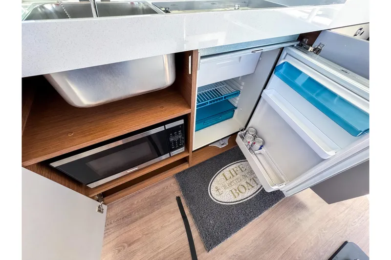Slide: The Image of Modern kitchen area in 2023 Beneteau Antares 11 with sink, microwave, and fridge. - 10