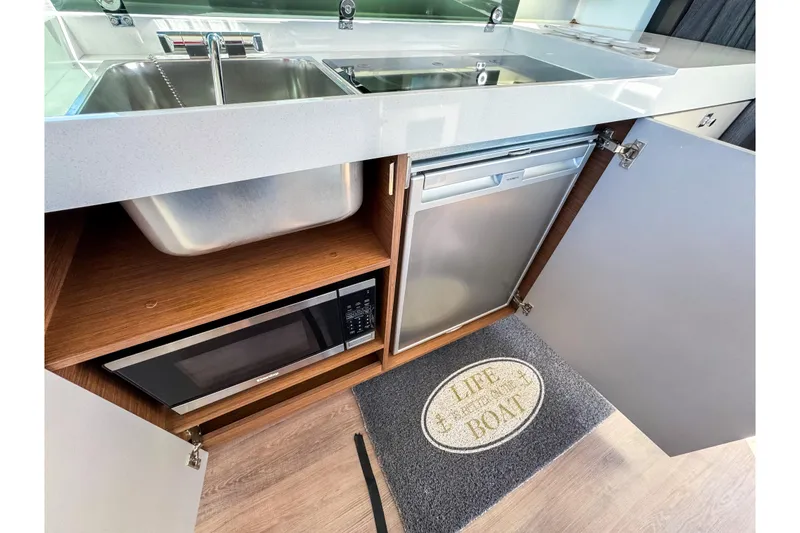 Slide: The Image of Modern kitchen area in 2023 Beneteau Antares 11 with sink, microwave, and fridge. - 11