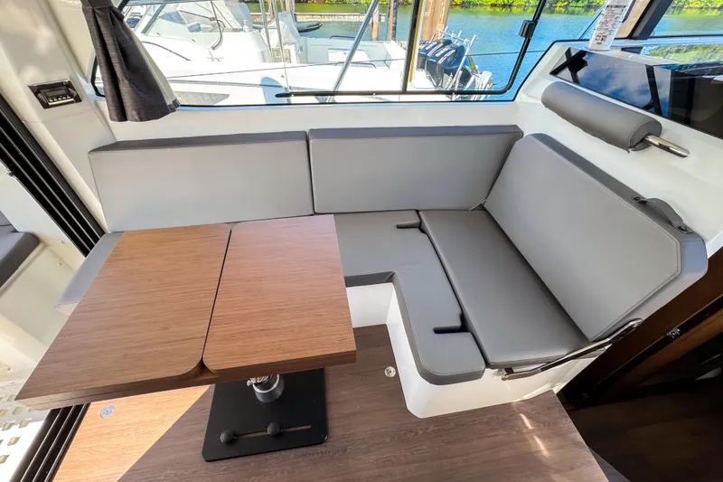 Slide: The Image of Interior of 2023 Beneteau Antares 11 with gray seating and wooden table. - 14