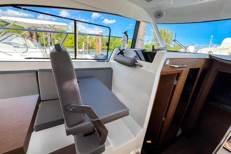Slide: The Image of Interior of 2023 Beneteau Antares 11, featuring seating and wooden cabinetry with scenic window views. - 15