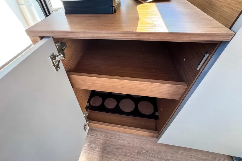 Slide: The Image of Open wooden cabinet inside 2023 Beneteau Antares 11 boat, featuring shelves and storage space. - 17