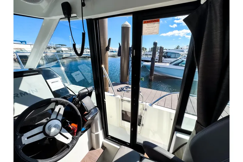 Slide: The Image of Interior view of 2023 Beneteau Antares 11 boat, showcasing helm and marina. - 19