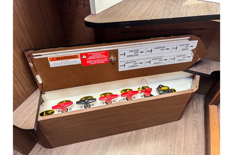 Slide: The Image of Electrical panel of 2023 Beneteau Antares 11 boat with labeled switches and warning signs. - 23