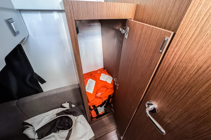 Slide: The Image of Storage cabinet with life jackets on a 2023 Beneteau Antares 11 boat. - 27