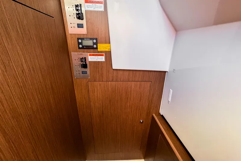 Slide: The Image of Control panel area in 2023 Beneteau Antares 11 with wood finish and warning labels. - 30