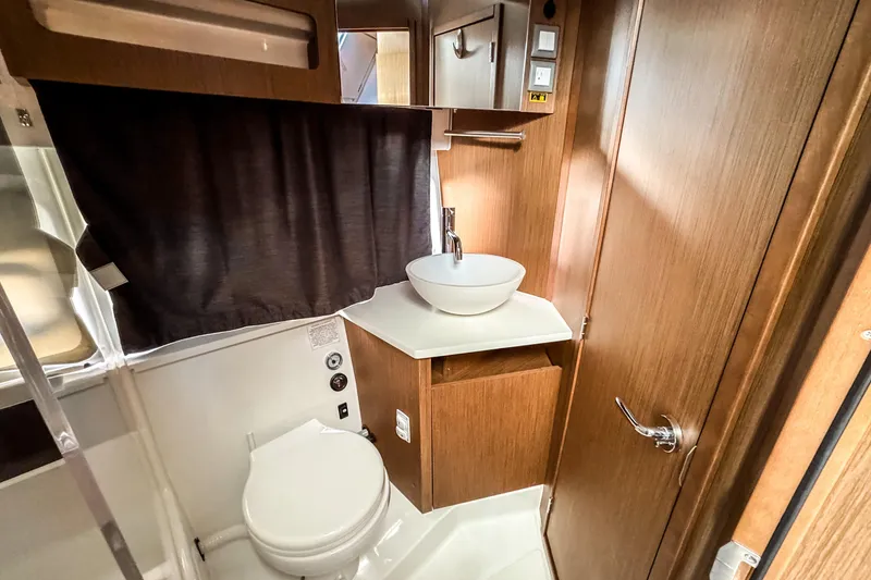 Slide: The Image of 2023 Beneteau Antares 11 bathroom with modern sink and wooden cabinetry. - 37