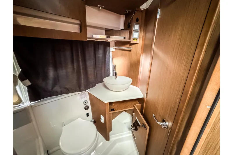 Slide: The Image of 2023 Beneteau Antares 11 bathroom with modern sink and wooden cabinetry. - 38