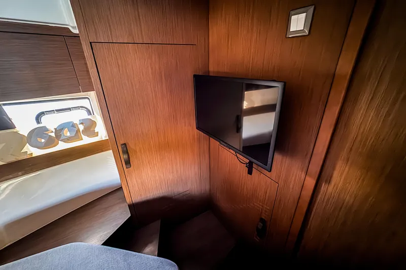 Slide: The Image of Interior of 2023 Beneteau Antares 11 with mounted TV and wooden paneling. - 40