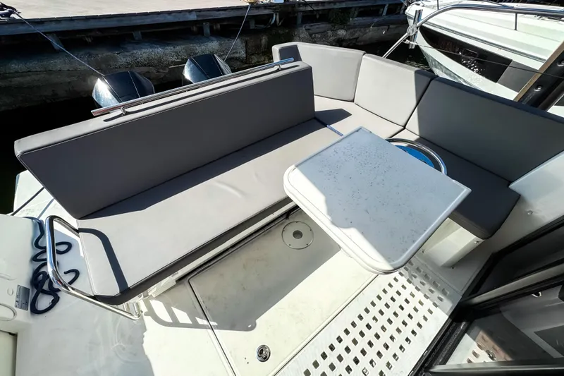 Slide: The Image of 2023 Beneteau Antares 11 boat deck with seating and table, docked at marina. - 6