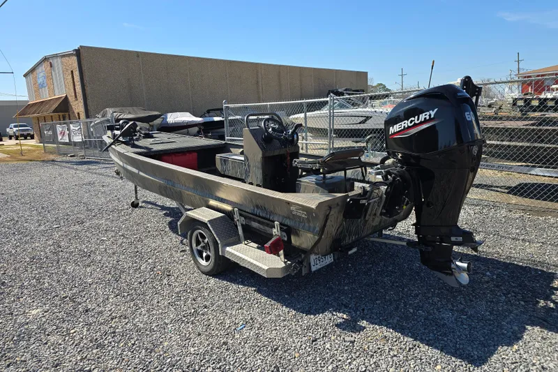 Slide: The Image of 2018 Pro-Drive 1754 boat with Mercury engine on trailer, parked outdoors. - 2